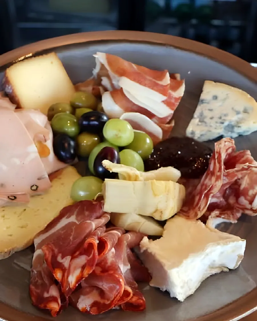 A sharing plate of cheese, charcuterie and olives